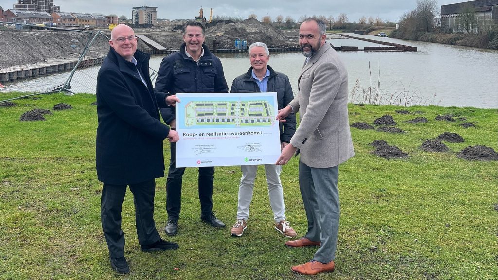 Wethouder Peter van Bergen van de gemeente Dronten, Leo de Vries (projectontwikkelaar Van Wijnen), Ed Gijsen (projectleider / senior beleidsmedewerker gemeente Dronten) en Thomas van Houwelingen (adjunct-directeur Van Wijnen Projectontwikkeling Noord) met de overeenkomst voor de ontwikkeling en realisatie van 96 woningen op veld 2 in het Hanzekwartier, Dronten